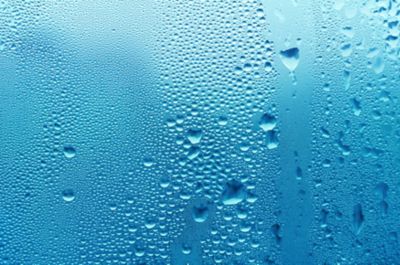 bubbling water droplets coming out of layer of water with steam around it