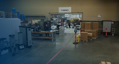 A wide shot of a nano warehouse, with equipment assembled and standing by, and nano workers handling products