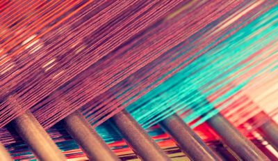 Multicolored straight strands texture background, sewing equipment, loom equipment at a garment factory