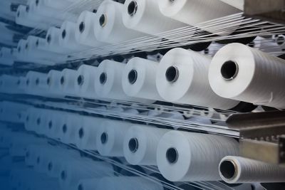 A wall of rolls hold freshly produced paper from paper pulp