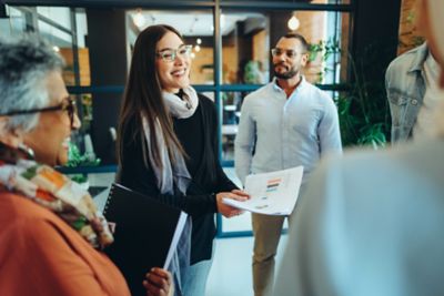 Cheerful businesspeople holding a staff meeting or sharing ideas in a modern office. 