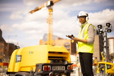 Construction worker seen with portable compressor
