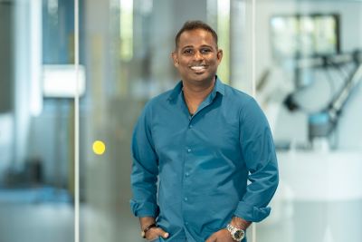 A middle-aged employee standing and smiling.