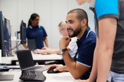 Profissionais colaborando no atendimento ao cliente em um ambiente corporativo moderno.