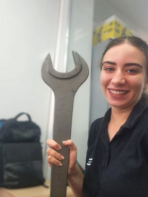 Sara Galal holding a very large wrench. 