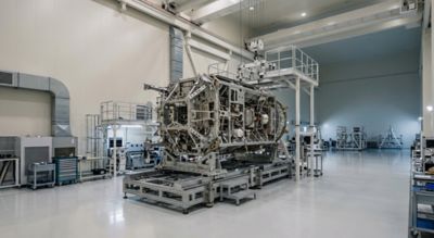 Satellite manufacturing concept in modern industrial facility with large metal structure