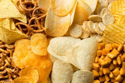 A layer of different chips, crackers, and pretzels
