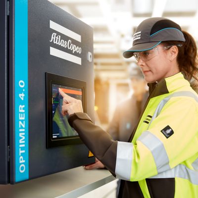 Female service technician looking at air compressor monitoring system