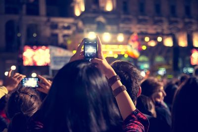 Supporters recording at concert using mobile phones.