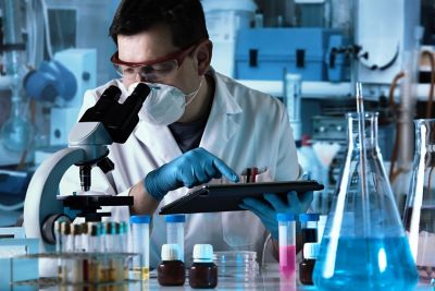 Researcher using digital tablet and microscope and working with samples in the laboratory.