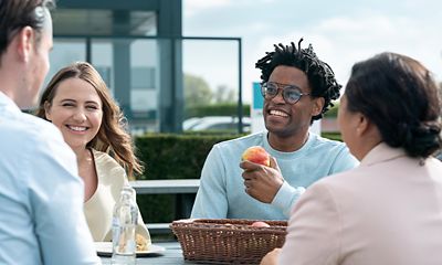 Employees catching up for a healthy snack in the open air in front of the office.