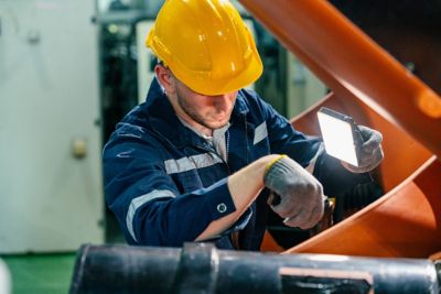 Image of a worker focuses on inspecting machinery.