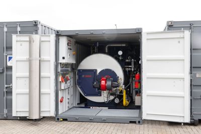 A portable warm water boiler housed in a shipping container with the doors open, showcasing its compact and efficient design.