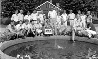 Svartvit bild på människor samlade runt en fontän 1984. En av dem håller en skylt med texten "Vatten åt Alla".