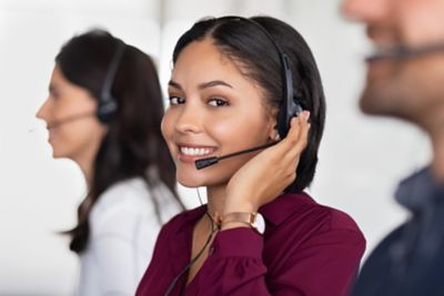 A smiling woman wearing a headset in a customer service area
