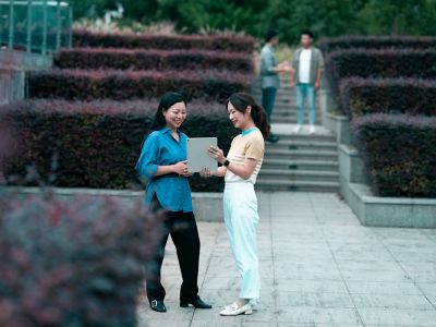 Women colleagues looking at a tablet screen in the outdoors