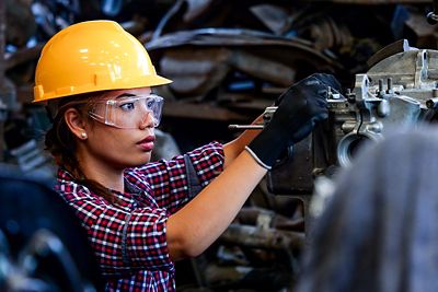 Young Asian Engineer woman  working with machine in factory.