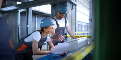 Workers in uniforms check air compressor system reference image