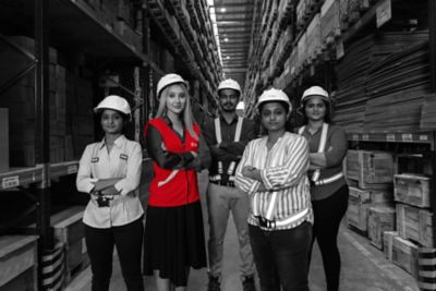 Group of workers posing among boxes in warehouse